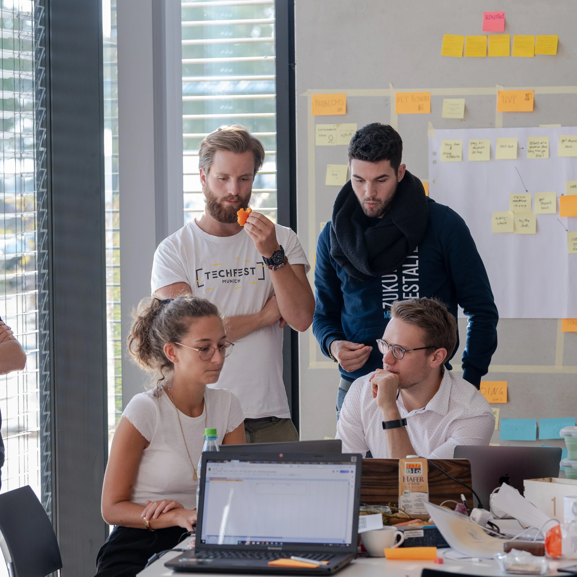 Mehrere Personen im Austausch um ein Laptop