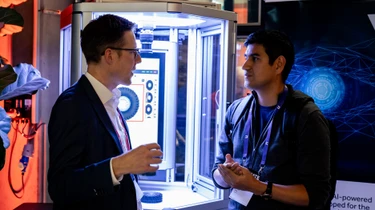 Two people in exchange in front of a machine